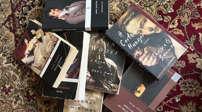 Bir İran halısının üzerine konmuş birbirinden farklı kapaklara sahip kitaplar.